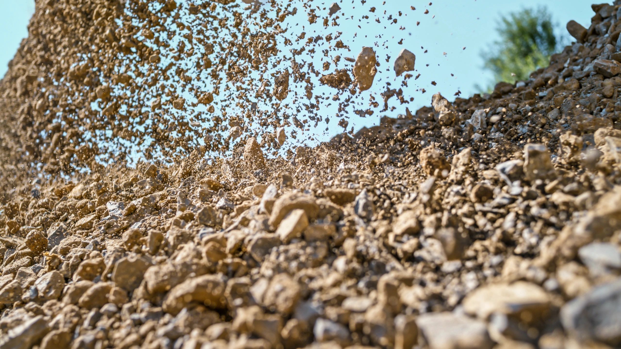 Gravel being unloaded from a digger bucket at a construction site